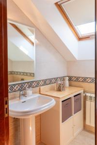 a bathroom with a sink and a mirror at Casa Xardín in O Pedrouzo