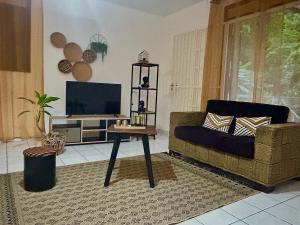 a living room with a couch and a table at Spacieux et lumineux Appartement T3 Cayenne in Cayenne