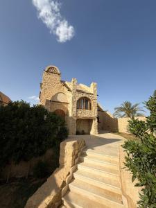 a stone building with stairs leading up to it at Tunis Village,lake view countryside villas in Tunis