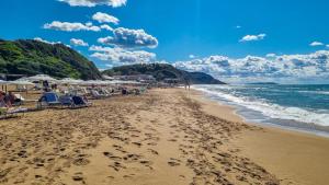 a beach with chairs and umbrellas and the ocean at Casa Verde in Marathias