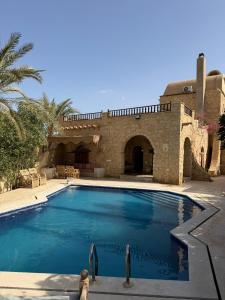 a swimming pool in front of a house at Tunis Village,lake view countryside villas in Tunis