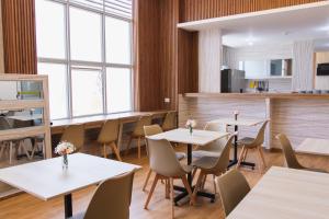 a restaurant with white tables and chairs and windows at Zentra Plaza Hotel & Cowork in Chiclayo