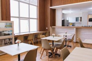 a restaurant with white tables and chairs and windows at Zentra Plaza Hotel & Cowork in Chiclayo +52 photos