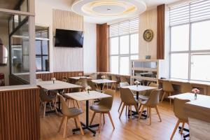 a restaurant with tables and chairs and a tv at Zentra Plaza Hotel & Cowork in Chiclayo