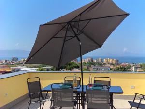 a table with chairs and an umbrella on a roof at Villa Carbonilla in Torre del Greco