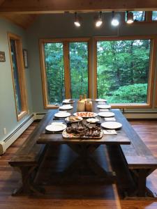 a large wooden table with plates of food on it at Shimmering Cove Retreat in Naples