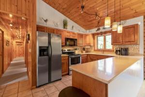 a kitchen with wooden cabinets and a stainless steel refrigerator at Shimmering River Retreat in Edgecomb