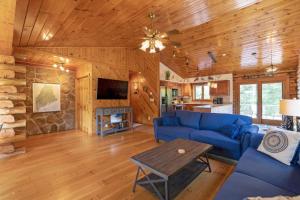 a living room with a blue couch and a table at Shimmering River Retreat in Edgecomb