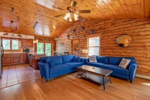 a living room with blue couches and a table at Shimmering River Retreat in Edgecomb