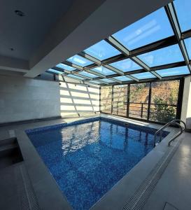 a swimming pool in a building with a large window at Hotel Elion in Yerevan