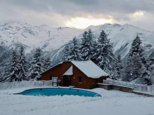 a cabin in the snow with mountains in the background at Le Cocon Bleu in Ustou