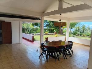 a dining room with a table and chairs at Aremiti - Fare Orotia in Taputapuapea