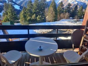 a white table and chairs on a balcony with a mountain view at Le Cocon Bleu in Ustou +2 photos