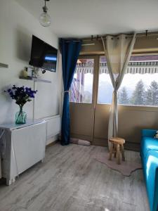 a living room with a blue couch and a window at Le Cocon Bleu in Ustou