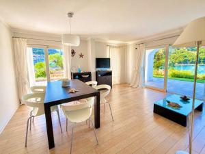 a living room with a dining room table and chairs at Poltu Quatu House in Porto Cervo