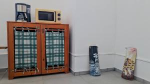 a tv sitting on top of a wooden cabinet with curtains at inScialla Hostel in Trapani