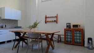 a kitchen with a wooden table and chairs at inScialla Hostel in Trapani +33 photos