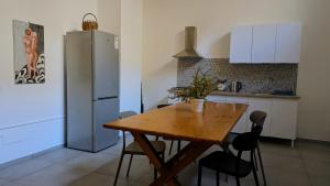 a kitchen with a wooden table and a refrigerator at inScialla Hostel in Trapani