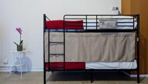 a iron bunk bed with a blanket on it at inScialla Hostel in Trapani