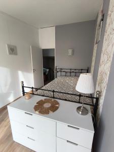 a bedroom with a bed with a lamp on a dresser at Maison 4 chambres proche Reims in Tinqueux +18 photos
