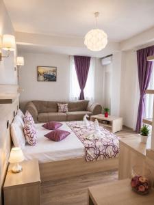 a living room with a large bed and a couch at HF - Mamaia Nord in Mamaia Sat/Năvodari