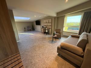 a living room with a couch and a window at Pinnø - Padel Hotel Food in Pinnow