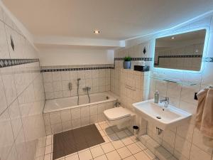 a bathroom with a sink and a tub and a toilet at Pinnø - Padel Hotel Food in Pinnow +48 photos