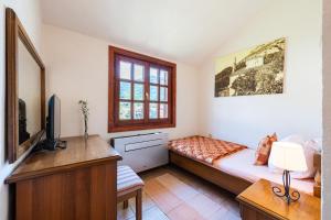 a bedroom with a bed and a desk and a television at Hotel Dubrava in Budva
