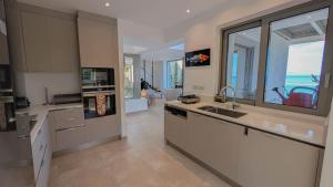 a kitchen with a sink and a large window at Villa Levanda in Kiveri