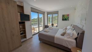 a bedroom with a bed and a television and a balcony at Villa Levanda in Kiveri