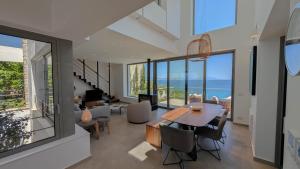 a dining room and living room with a view of the ocean at Villa Levanda in Kiveri