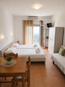 a bedroom with two beds and a table and a couch at Τηλεμαχος Apartments in Loutra Edipsou