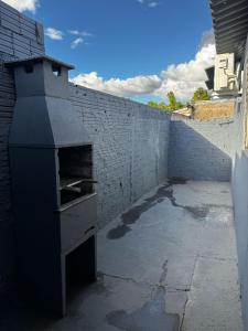 an outdoor oven sitting next to a brick wall at Casa Aconchego 2, Self Check-in in Presidente Prudente
