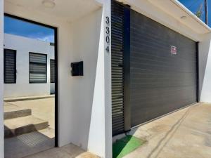 a garage door on a white building with stairs at House Ayala 2BR 2Bd in Rosarito