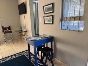 a blue table with two stools in a room at Casa Aconchego 2, Self Check-in in Presidente Prudente