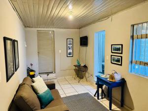 a living room with a couch and a table at Casa Aconchego 2, Self Check-in in Presidente Prudente