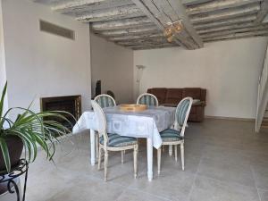 a table and chairs in a living room with a couch at Au petit soulier de Puisaye in Treigny