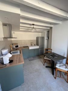 a kitchen with blue cabinets and a table in it at Au petit soulier de Puisaye in Treigny