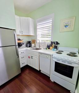 a kitchen with white appliances and a white refrigerator at Duval Street Suite with pool in Key West