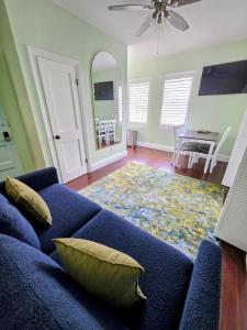 a living room with a blue couch and a table at Duval Street Suite with pool in Key West