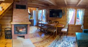 a living room with a fireplace and a dining room table at Leonówka in Nowogród