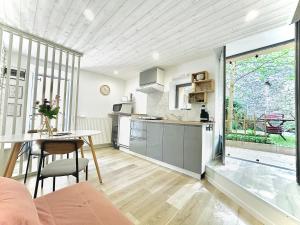 a kitchen with a table and a dining room at Gîtes des Bourguerins - Hébergement de charme & Etape Motards in Menotey