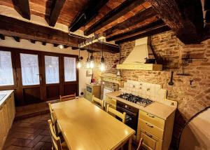 a kitchen with a wooden table and a stove at Dimora del Campanile in Torrita di Siena +10 photos