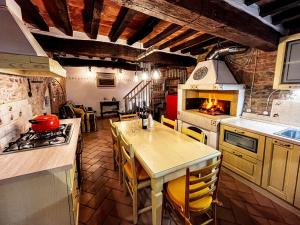 a kitchen with a table and a stove top oven at Dimora del Campanile in Torrita di Siena