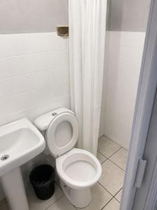 a bathroom with a white toilet and a sink at Quarto em Matinhos | Viva o Melhor do Litoral in Matinhos