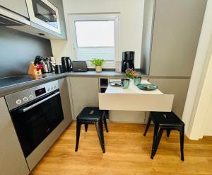 a small kitchen with a small table and two stools at Tiny House Boddenblick in Groß Kordshagen