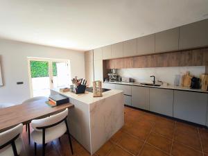 a large kitchen with a table and a counter top at CASA CAPUCINE in Rio Caldo