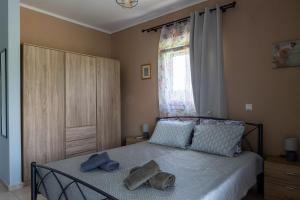 a bedroom with a bed with two hats on it at Lanari Valley House 2 in Thermi