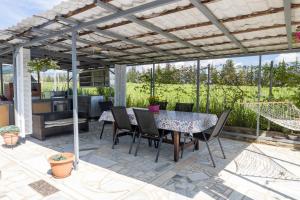 a patio with a table and chairs under a pergola at Lanari Valley House 2 in Thermi