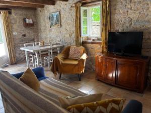 a living room with a couch and a tv at Laborie in Meyronne